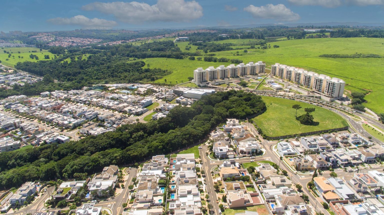 Vista aérea de área urbana de Campinas, com bairros residenciais, ruas e trechos de vegetação