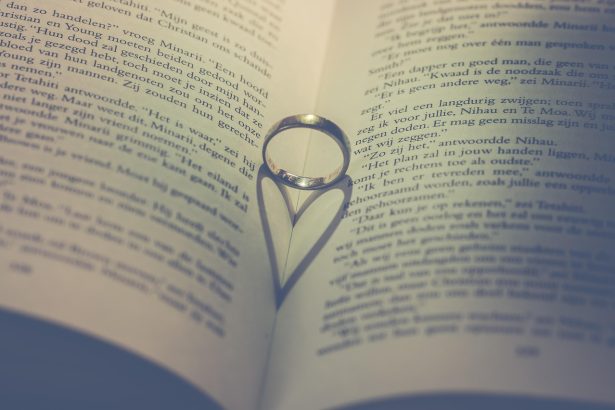 Anéis sobre as páginas de um livro, em uma composição associada a amor, pedido de casamento e união.